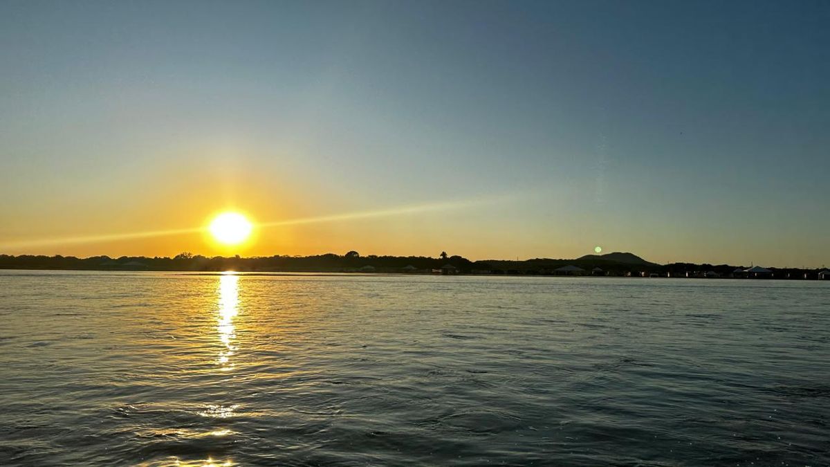 Praia de areia clara e o Rio Araguaia ao nascer do sol