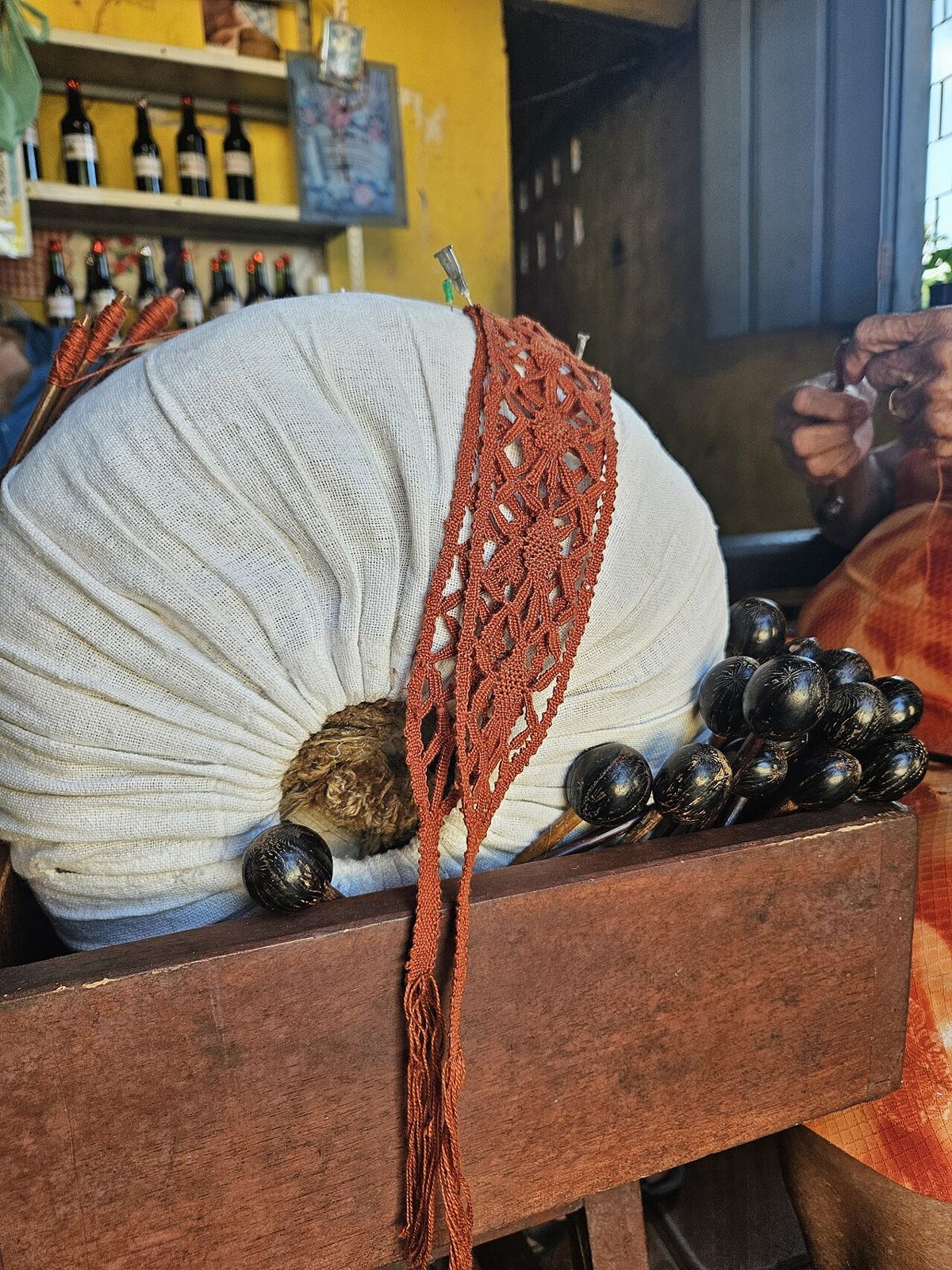 Renda de bilro na almofada, com os bilros pendurados