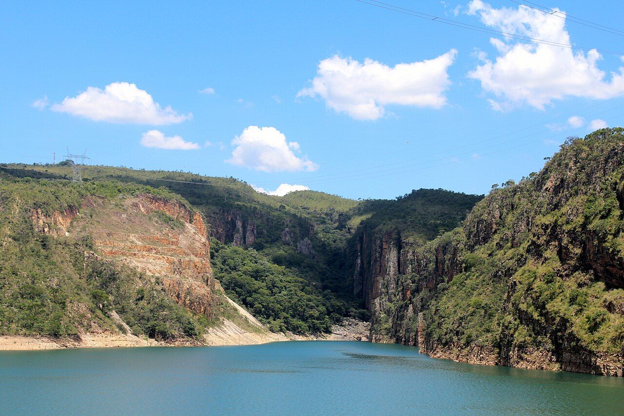 Mata, rochas e praia na beira do Lago de Furnas